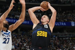Nikola Jokic (à droite) arme son shoot face à Rudy Gobert. KEYSTONE/AP/David Zalubowski